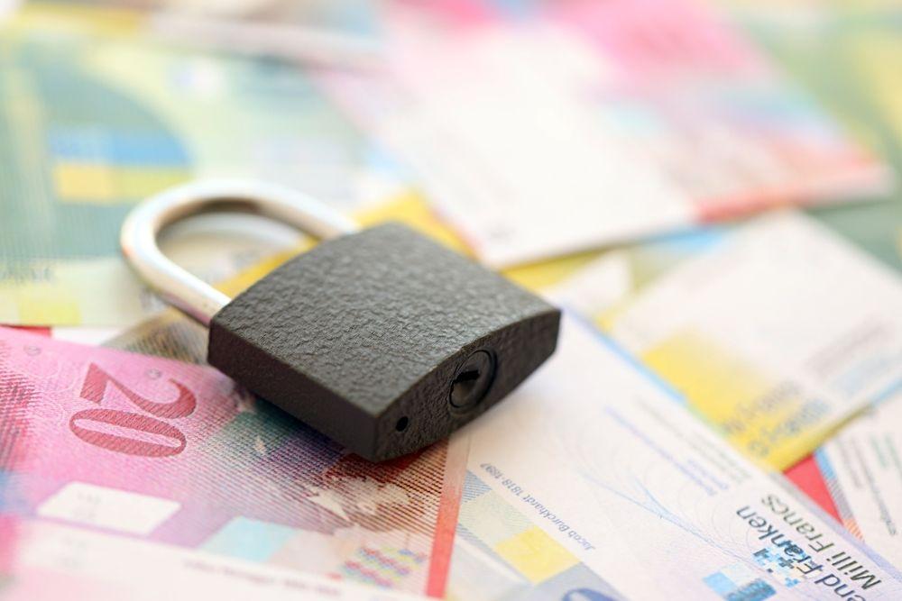 Padlock placed on currency notes, representing risk management, capital protection, and secure investment frameworks